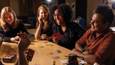 Friends laughing together during a group game night